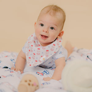 cute baby looking up in yogurt drink bib